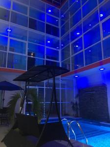 帕拉伊索Hotel Empresarial的大楼内带遮阳伞的游泳池
