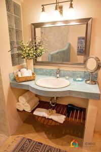 拉巴斯Casa Oasis的浴室配有盥洗盆、镜子和毛巾
