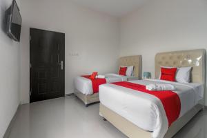 北干巴鲁RedDoorz near Mall SKA Pekanbaru的一间卧室配有两张床和电视。
