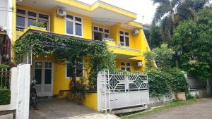 茂物茂物岑达纳穆拉旅舍的前面有白色门的黄色房子