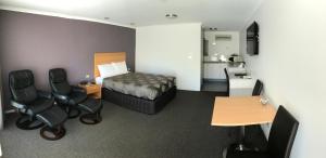 Barooga运动家汽车旅馆的酒店客房,配有一张床、一张桌子和椅子