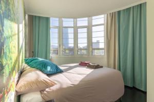 毕尔巴鄂BIG LUX BEACHCITY Ap 01的卧室配有带枕头的床铺和窗户。