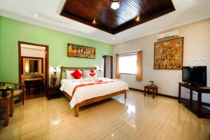 罗威那巴厘岛塔曼海滩及Spa罗维纳度假酒店的一间卧室配有一张床和一台电视