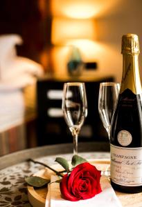 埃文河畔斯特拉特福Baraset Barn Hotel的一瓶葡萄酒和一朵玫瑰花在玻璃边