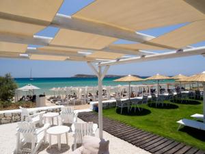 克里希阿克提阿玛丽利斯海滩酒店的海滩上设有白色椅子和遮阳伞的餐厅