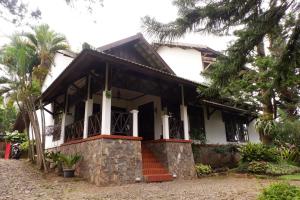巴图OYO 604 Cemara's Homestay的白色的房子,前面有楼梯