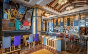 韦克斯福德瓦克斯福德塔尔波特酒店的餐厅设有1间带紫色椅子的酒吧