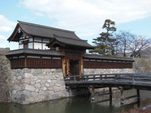 长野Guesthouse Matsushiro Walkers的水体上的一座桥上的建筑物