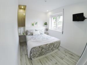 波尔图Casa d'Avó的白色的卧室设有床和窗户