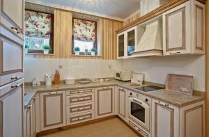 Mogilovo米达里达尔Spa酒店的厨房配有白色橱柜和炉灶烤箱。
