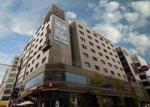 仁川市Guwol Hotel的一座高大的建筑,上面有标志