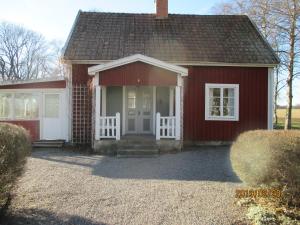 SkänningeStuga Olstorp的一间红色的小房子,有白色的门