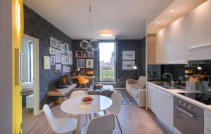 米兰波尔塔沃尔卡公寓酒店的厨房以及带桌椅的起居室。