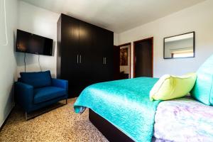 蒂哈拉费CASA LUJAN的一间卧室配有一张床和一张蓝色椅子