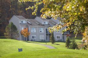 东斯特劳兹堡Pocono Mountain Villas by Exploria Resorts的一座大房子,位于一座小山上,拥有绿色庭院