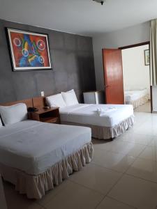 圣萨尔瓦多阿尔柏德苏诺斯酒店的酒店客房设有两张床,墙上挂有绘画作品