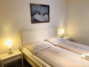 圣斯蒂凡安德Assingerhof的配有两张床铺的房间,桌子上放着两盏灯