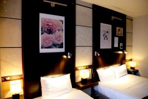 比居格利亚库尔斯酒店的酒店客房设有两张床和两盏灯。