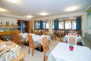 卡尔达罗PENSION KLUGHAMMER的一间设有白色桌椅的用餐室和一间餐厅