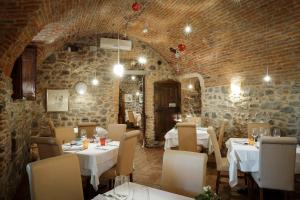 卡洛尔齐奥科尔泰罗坎达奥斯特马拉西亚度假屋的一间设有白色桌椅的餐厅,拥有砖墙