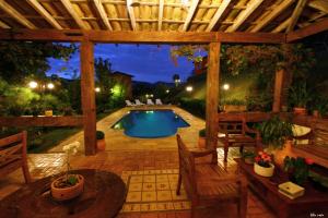 蒂拉登特斯A Casa Vermelha Hospedaria的后院设有游泳池和木制凉亭