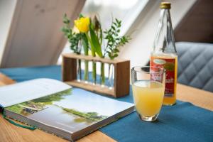 汉堡汉堡古老国度假日公寓的一本书旁边一杯橙汁和一瓶