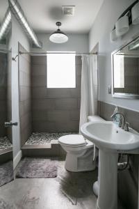 底特律Hostel Detroit的浴室配有卫生间、盥洗盆和淋浴。