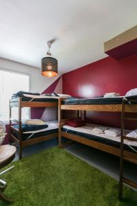 底特律Hostel Detroit的带三张双层床的客房,铺有绿色地毯。
