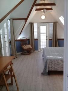 西班牙港Trinidad Gingerbread House的一间卧室,卧室内配有一张床和一把椅子