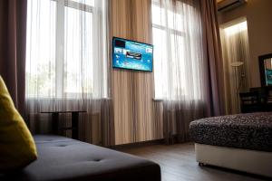 敖德萨艾阿卡迪亚精品公寓酒店的酒店客房,设有床铺和窗户上的电视