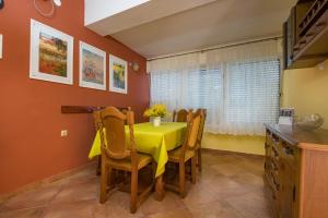蒂瓦特Holiday Home Nives的用餐室配有黄色的桌子和椅子