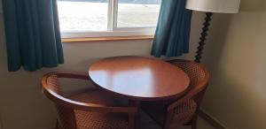 新奥尔良市Pacific Inn的一张木桌和两把椅子在窗前