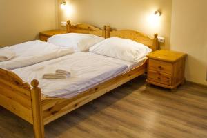 诺维萨尔多夫Pizzerie Jasany的一间卧室配有两张带白色床单的床和床头柜