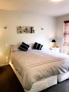 Riverhead薰衣草山酒店的卧室配有一张带黑色枕头的大型白色床。