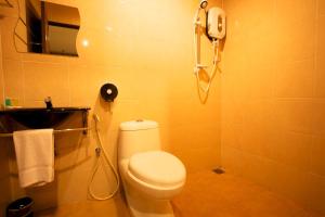 怡保德波塔尼酒店的一间带卫生间的浴室和墙上的一部电话