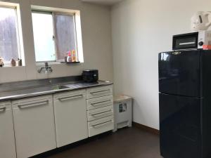 近江八幡市缘度假屋的厨房配有黑色冰箱和水槽
