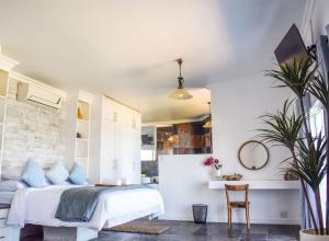 阿曼济姆托蒂Santorini Guesthouse的一间卧室配有一张床和一张桌子