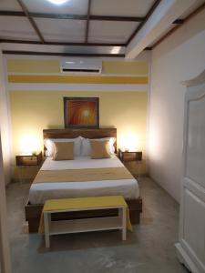 托舵道斯Casa Frangipani Mauritius的一间卧室配有一张带黄色长凳的大床