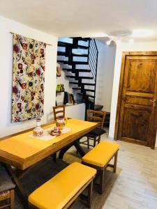 因佩里亚La casetta di Giuci的一间带桌椅和楼梯的用餐室