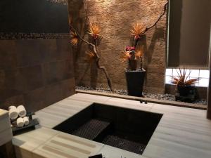 杨梅桃园依蝶汽车旅馆的浴室配有带植物的浴缸。