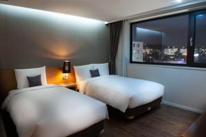 首尔首尔情侣酒店的酒店客房设有两张床和窗户。
