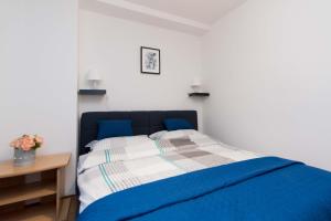 达鲁瓦尔Apartman Lux的一间卧室配有一张蓝色的床和一张桌子