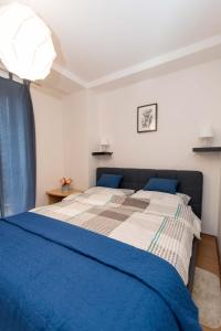 达鲁瓦尔Apartman Lux的卧室配有蓝色和白色的床和窗户。