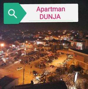 弗拉涅Apartman DUNJA的夜间有读阿根廷杜鲁纳的标牌的城市