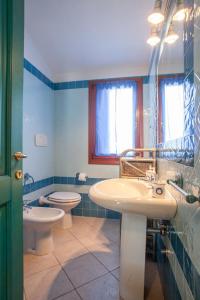 奥尔比亚Maestrale Flat - Klodge的浴室设有2个卫生间、水槽和卫生间。