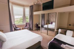 爱丁堡Braid Hills Hotel的酒店客房,设有两张床和镜子