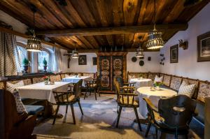 佩特诺伊阿尔贝格格瑞德伦酒店的餐厅设有桌椅和木制天花板。