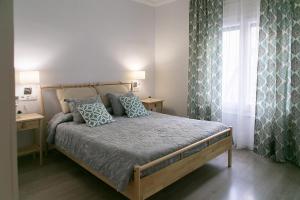 巴塞罗那布兰卡旅馆的一间卧室配有一张带蓝色枕头的床和一扇窗户。