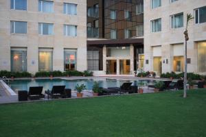 BhiwadiFortune Park Orange, Sidhrawali - Member ITC's Hotel Group的酒店庭院设有椅子和游泳池