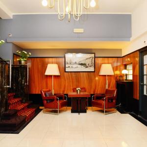 马斯特里赫特杜卡斯克阿姆拉斯酒店酒店的一间设有椅子、一张桌子和吊灯的等候室